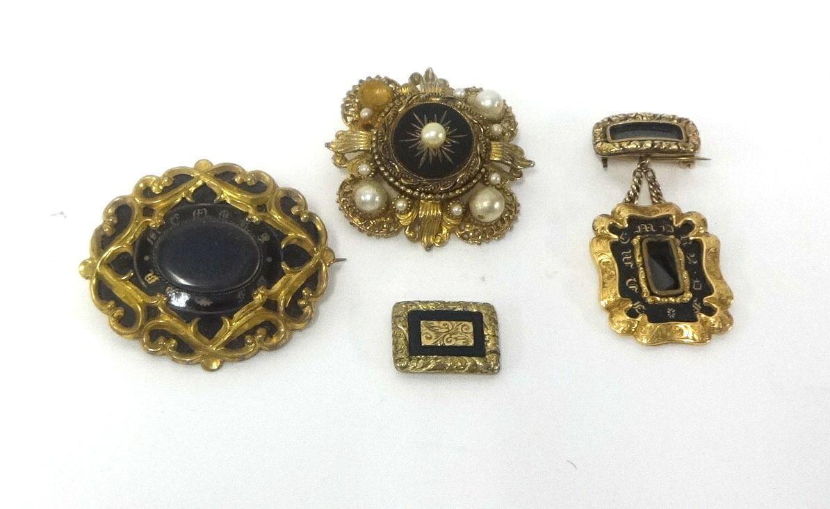 A Victorian pinchbeck mourning brooch and three other brooches (4).