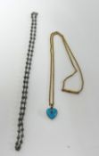 A small enamelled heart shaped pendant on a fine gilt chain, also a black pearl necklace (2).