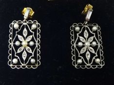 A pair of diamond and pearl earrings.