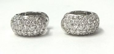 A pair of 18ct white gold and diamond ear clips, pave set with brilliant cut stones, total diamond