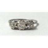 A white metal three stone diamond ring, claw set with graduated old cut stones, total weight