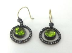 A pair of antique peridot hoop earrings.