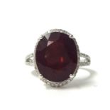 A 14k white gold and diamond ring set with an oval cut ruby, approx. 9ct, diamonds approx. 0.40ct