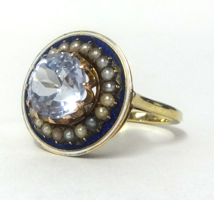 A large pale sapphire ring set within a band of seed pearls and blue enamel, set in a yellow metal - Image 2 of 2
