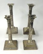 A set of four Mappin and Webb silver candlesticks, modelled as Corinthian columns, raised on stepped