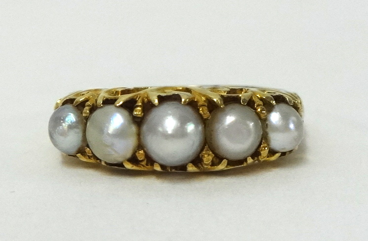 A five stone pearl ring, set in yellow metal, size L 1/2.