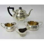 A pair of silver sugar tongs, silver plated wares including a three piece tea set, three wine bottle