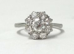 A diamond and platinum cluster ring, of good colour and clarity, the centre stone approx. 0.50