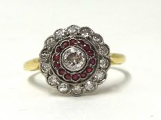 An antique diamond and ruby cluster ring, the centre stone with a band of ruby and outer band of