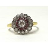 An antique diamond and ruby cluster ring, the centre stone with a band of ruby and outer band of