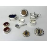 Various silver wares including table salt, napkin rings, mustard pot, miniature circular photo