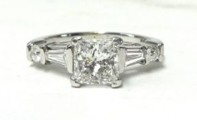 A 14ct white gold princess cut diamond ring with baguette and round diamonds on shoulder, size J 1/