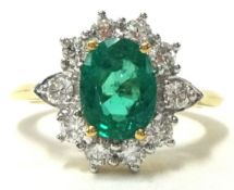 An emerald and diamond cluster ring, size N.