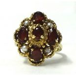 A large 9ct gold garnet and pearl ring, size T.