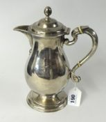 An Irish silver hot water jug, Dublin, heavy gauge, of baluster form with engraved crest, hallmark