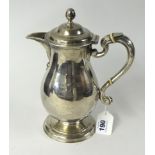 An Irish silver hot water jug, Dublin, heavy gauge, of baluster form with engraved crest, hallmark