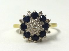 An 18ct sapphire and diamond cluster ring, size V.