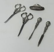 Two silver nail scissors, file, buffer and cuticle.