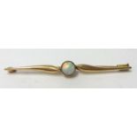 A gold and opal bar brooch, set with a single cabochon set opal, stamped .585.