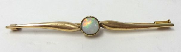 A gold and opal bar brooch, set with a single cabochon set opal, stamped .585.