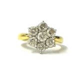 An 18ct gold and diamond cluster ring, claw set with seven brilliant cut stones, the shank stamped