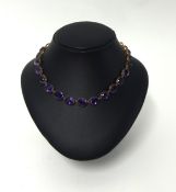 An amethyst necklace, set with graduated stones, in probably rose gold, length 40cm.