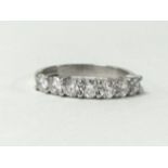 An 18ct white gold seven stone diamond ring, claw set with brilliant cut stones, total weight