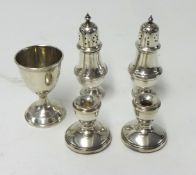 Silver egg cup, a pair of miniature silver candle holders and two silver salts.