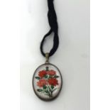 An oval pendant decorated with a porcelain rose flower set on mother of pearl, 25mm long.