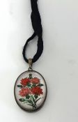 An oval pendant decorated with a porcelain rose flower set on mother of pearl, 25mm long.