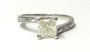 A white metal and single stone diamond ring, claw set with a Princess cut stone of approximately 0.