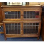 An oak two section Minty style bookcase with leaded glazed doors on turned legs, width 90cm,