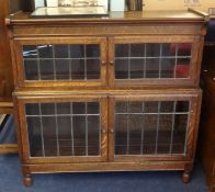 An oak two section Minty style bookcase with leaded glazed doors on turned legs, width 90cm,