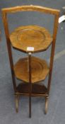 An oak three tier cake stand and a canteen cutlery box.