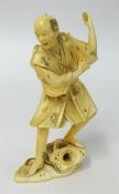 A carved ivory figure of a man with net (damaged), red seal mark to base height 12cm