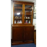 A Victorian mahogany bookcase, the upper section with two glazed doors over a base fitted with three