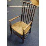 An oak framed traditional nursing chair with barley twist supports and rush seat