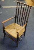 An oak framed traditional nursing chair with barley twist supports and rush seat