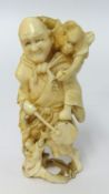 A carved ivory figure of a man with an instrument and a monkey upon his shoulder, height 9cm