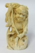 A carved ivory figure of a fisherman with his catch