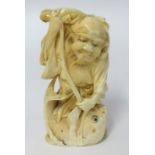 A carved ivory figure of a fisherman with his catch