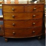 An early mahogany chest fitted with two short and three long drawers, bow fronted on turned legs.