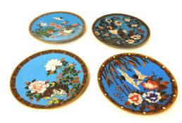 Four Cloisonné plates each decorated with exotic birds.
