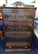 A mahogany three section Globe Wernicke style bookcase with leaded glazed doors and lower fitted