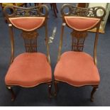 A pair of Edwardian carved wood nursing chairs.