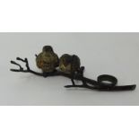 A bronze model of two birds on a branch.