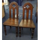 A pair of Victorian oak hall chairs.