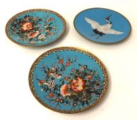 A pair of cloisonné plates decorated with birds together with a single plate decorated with a