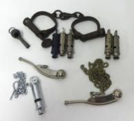 A collection of old whistles and handcuffs.