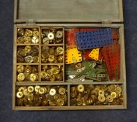 A wooden box containing Meccano parts including strips, plates etc
